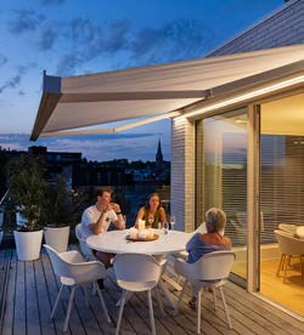 Chauffage radiant allumé sous un store banne Brustor éclairé par une bande LED