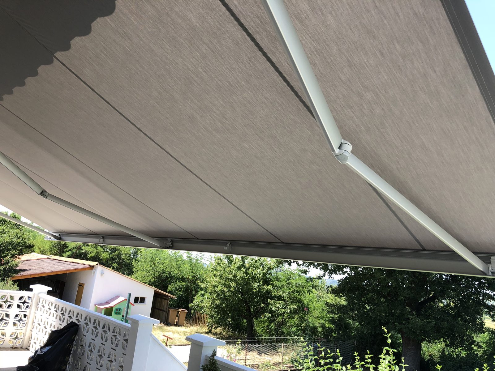 Vue sous la toile du store banne déployé au-dessus du balcon