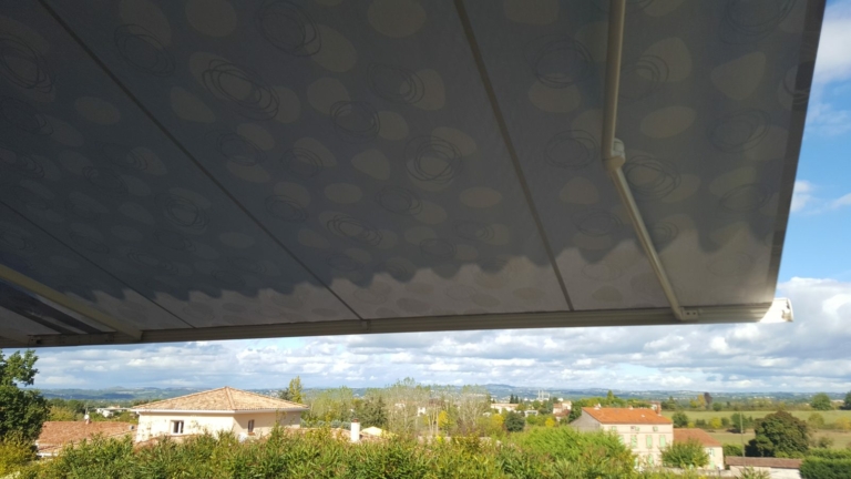 Toile de store banne déployée face à la campagne