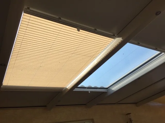 Store plissé tendu sous une toiture vitrée