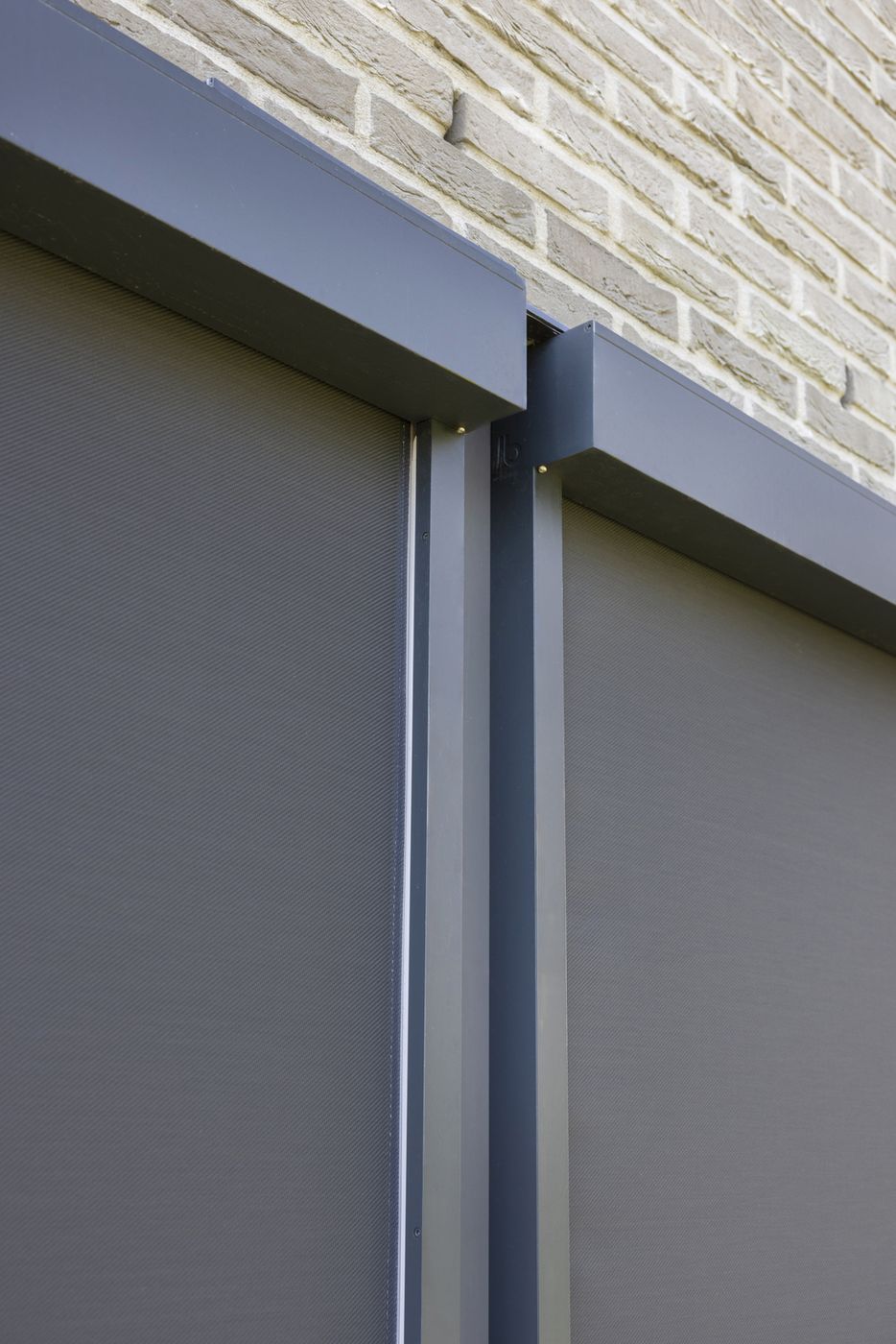 Détail du coffre et de la coulisse ZIP d'un screen Brustor sur une façade en brique