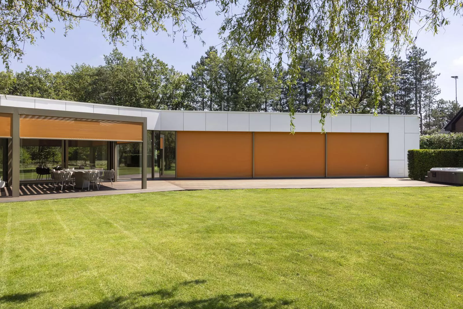 Stores verticaux ZIP Brustor à toile orange sur une maison de plain-pied