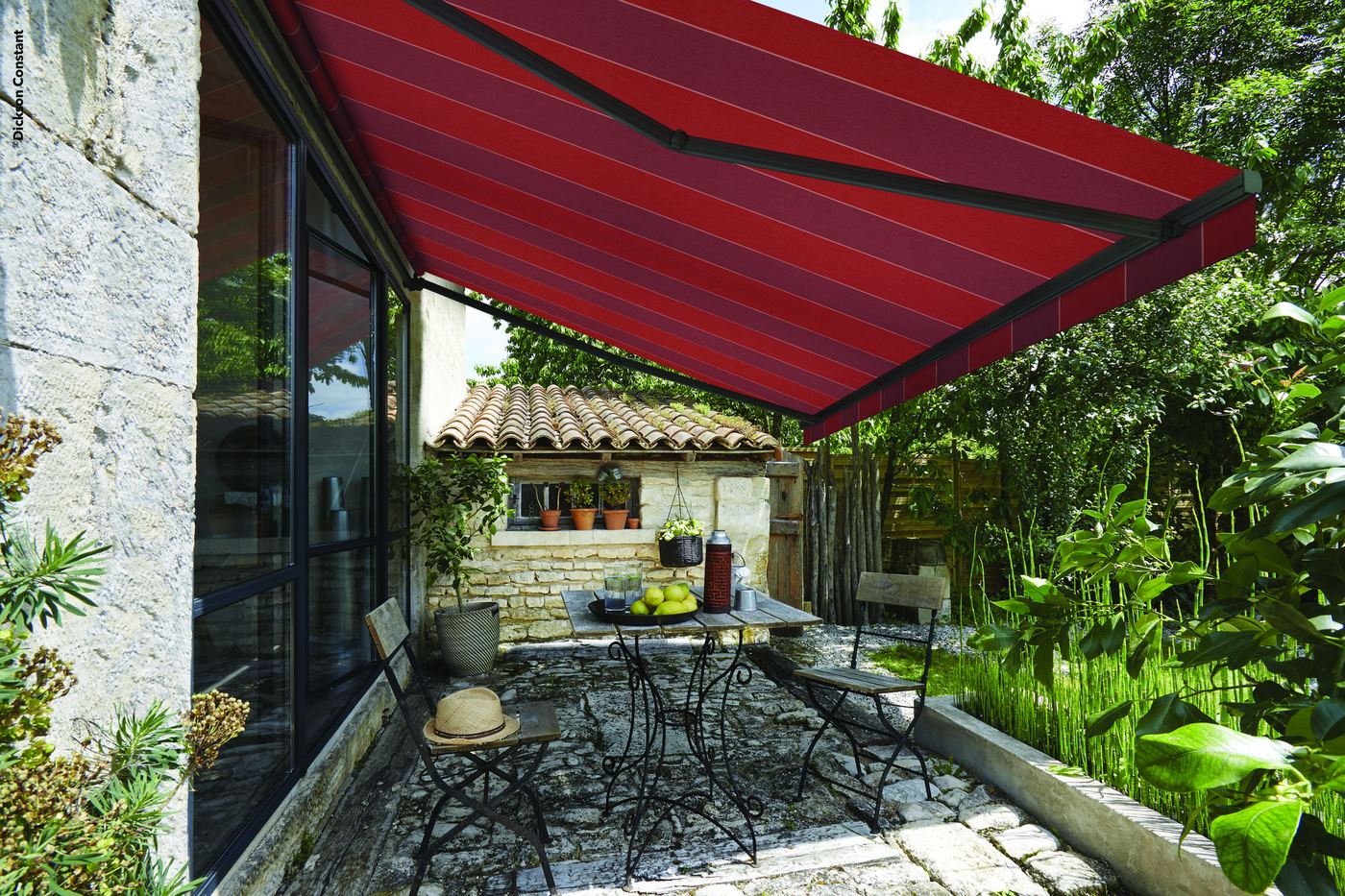 Store banne à toile Dickson Orchestra rouge rayée au-dessus d'un patio