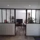 Verrière intérieure à montants noirs séparant un bureau du salon