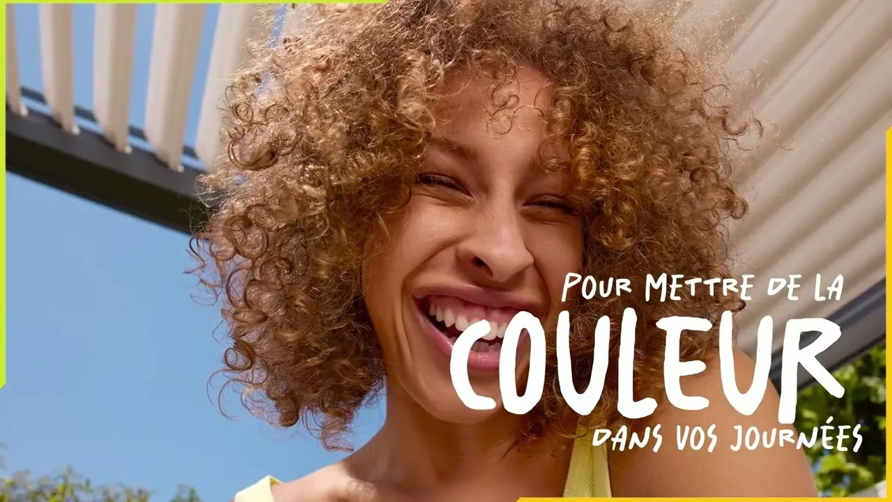 Femme souriante sous une pergola bioclimatique, image de la vidéo EXTEND Vivre sa terrasse autrement