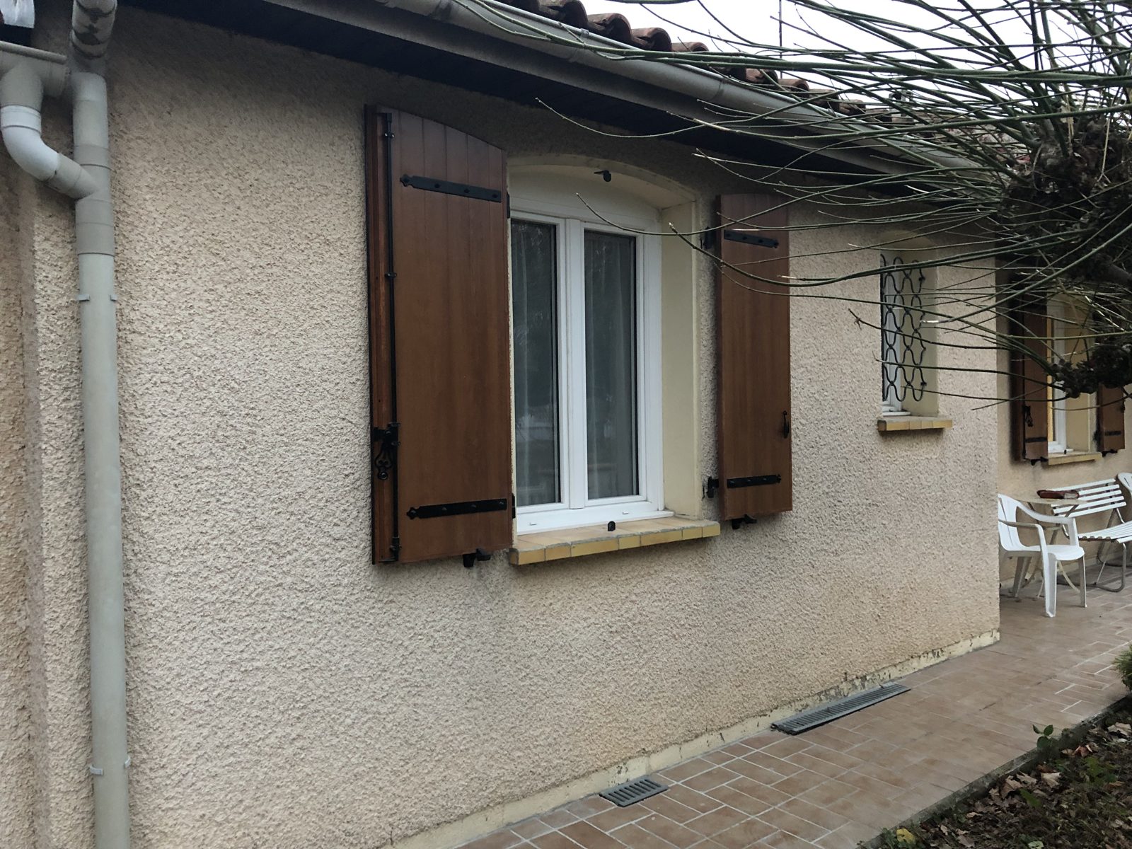 Volets battants aspect bois sur la façade de la maison