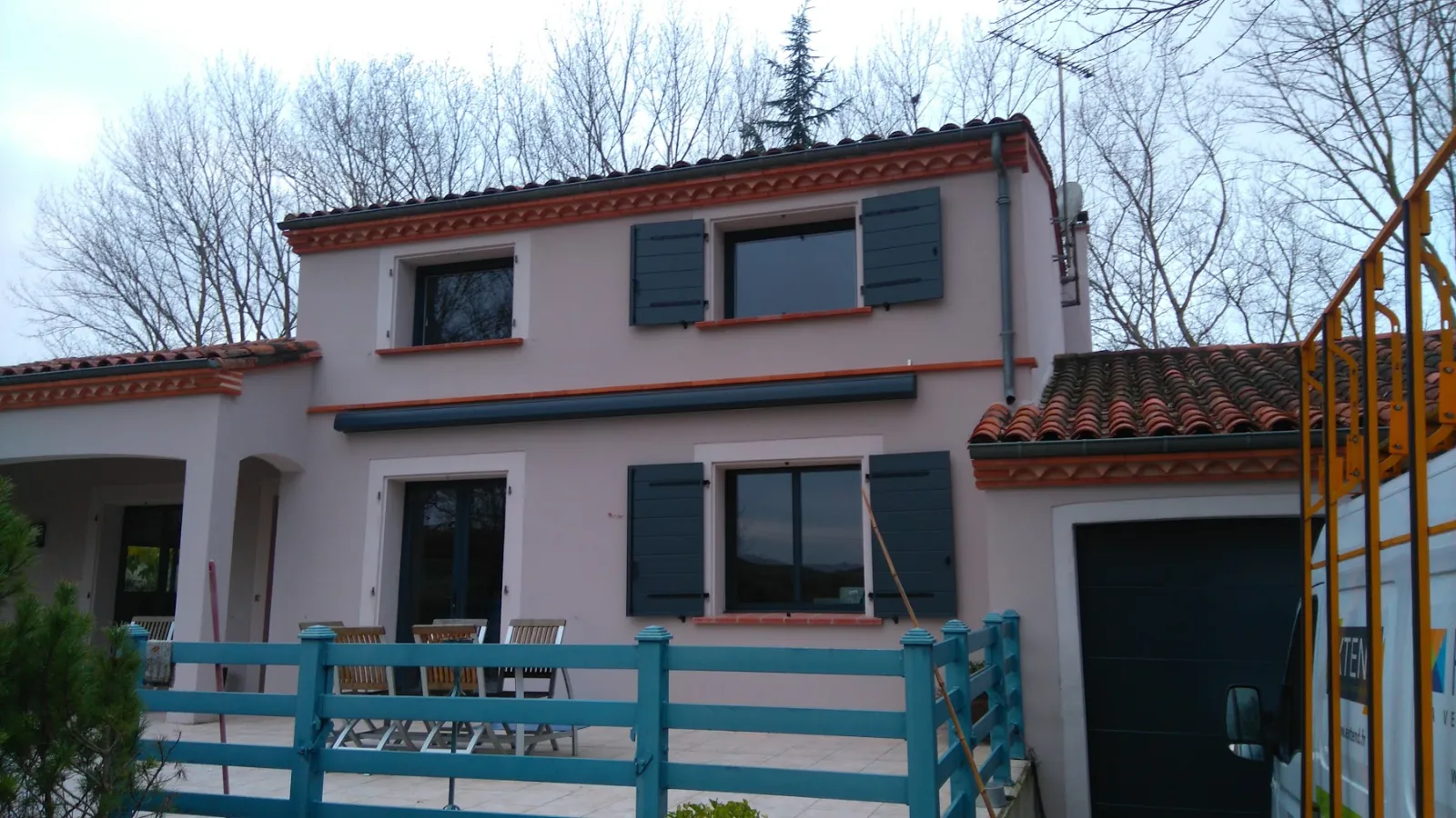 Volets battants gris sur une façade enduite